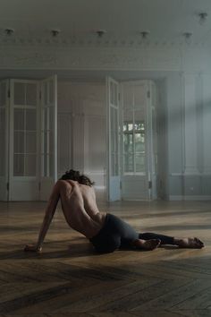 a shirtless man laying on the floor in an empty room