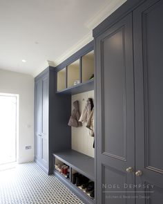 a room with gray cabinets and shoes on the shelves in it's closets