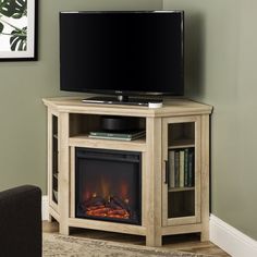 a flat screen tv sitting on top of a wooden stand next to a fire place