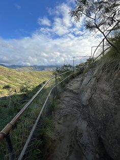 a fenced in path leading to the top of a hill