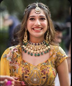 a woman in a yellow dress smiles while holding something