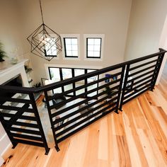 an overhead view of a living room with wood flooring and black iron railings