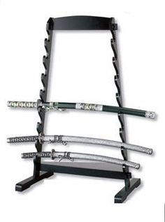 a black rack with four different types of swords on it and the bottom one is empty