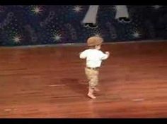 a little boy standing on top of a wooden floor