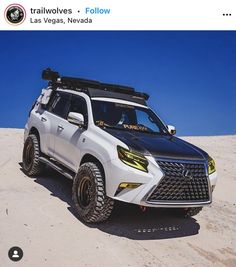 a white suv parked on top of a sandy beach