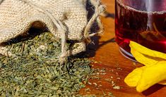 a cup of tea next to a sack of dried herbs and a banana peel on a wooden table