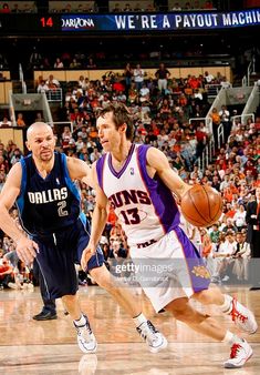 two basketball players in action on the court with fans watching from the stands behind them