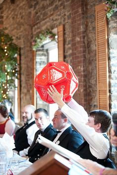 a woman holding up a red frisbee in front of a group of people