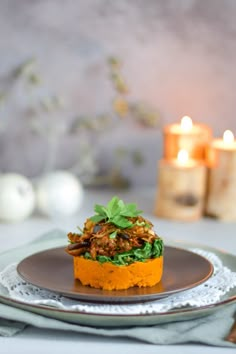 a plate with some food on it and candles in the backgroung behind it