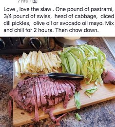 a wooden cutting board topped with sliced meat and veggies