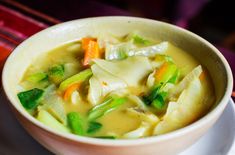 a white bowl filled with soup on top of a plate