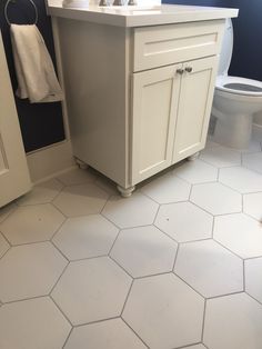 a white bathroom with blue walls and hexagonal tile flooring on the floor