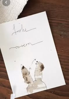 a piece of paper with a drawing of a rabbit on it next to a napkin