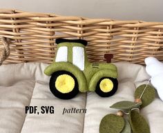 a green toy tractor sitting on top of a bed next to a stuffed animal bear