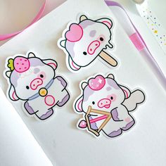 three stickers with animals on them sitting next to a pink pen and some scissors