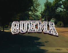 an image of the word quema written in large letters on top of a street