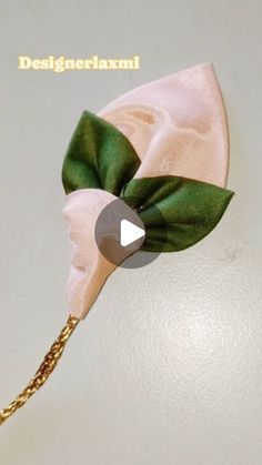 a green and white bow on top of a headband with gold chain attached to it