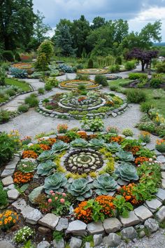 a garden with many different types of flowers and plants in the center, surrounded by rocks