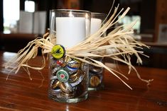 a glass filled with lots of different types of buttons on top of a wooden table