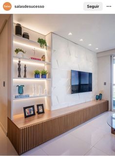 a living room filled with furniture and a flat screen tv mounted on a wall next to a window