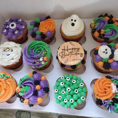 a box filled with lots of cupcakes covered in frosting and decorated to look like monsters