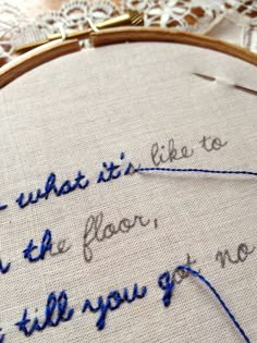 a close up of a embroidery on a piece of cloth with words written in it