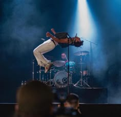 a man is performing on stage with his legs in the air