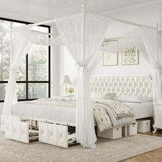 a white canopy bed sitting in a bedroom next to a window