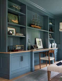 a living room filled with furniture and bookshelves covered in blue painted wood paneling