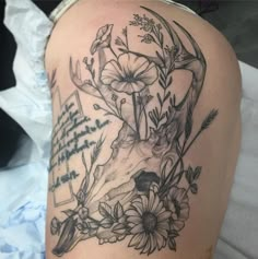 a tattoo with flowers and a deer's head