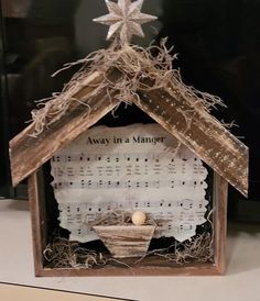 a nativity scene made out of wood and paper with an ornament in the center