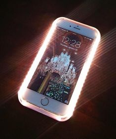 an iphone is lit up with glowing lights