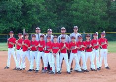 a baseball team is posing for a photo on the field with bats in their hands