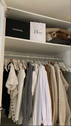 the closet is full of clothes and bags