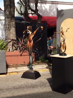 two sculptures on pedestals in the middle of a street