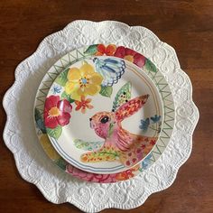 the plate is decorated with colorful flowers and an image of a bird on it's side