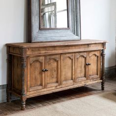 a large mirror is on the wall above a wooden cabinet