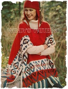 a woman wearing a red and white sweater standing in the woods with her arms crossed