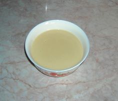 a white bowl filled with liquid on top of a table