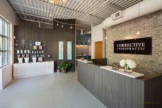 the front desk of a hair salon with brick wall and ceilinging, along with large windows