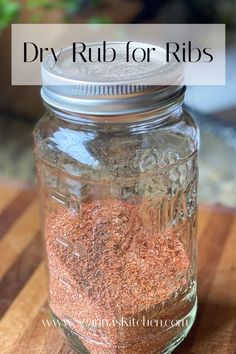 a jar filled with dry rubs on top of a wooden table