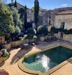 an outdoor swimming pool surrounded by stone buildings