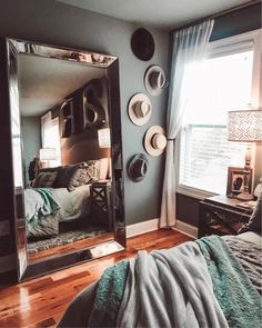 a bedroom with a large mirror and hats on the wall