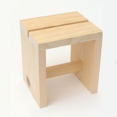 a small wooden stool sitting on top of a white floor