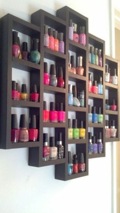 a wall mounted shelf filled with lots of nail polish