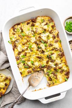 a casserole dish with meat, cheese and green onions in it on a table