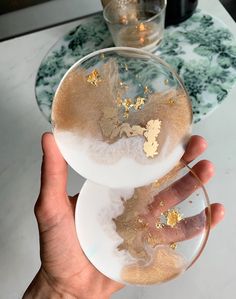 a person holding a wine glass with gold flakes on it