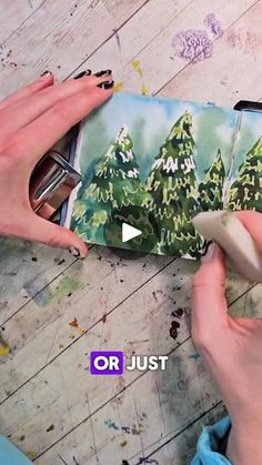 someone is painting trees on a piece of paper