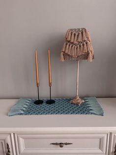 two candles are sitting on top of a dresser