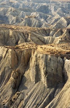 an aerial view of mountains and valleys in the desert